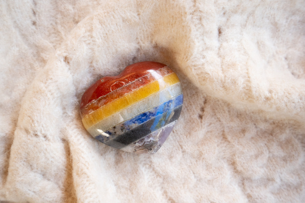 New products collection banner for The Tiny Topaz showing one banded heart-shaped crystal, nestled cozy on a knitted blanket.