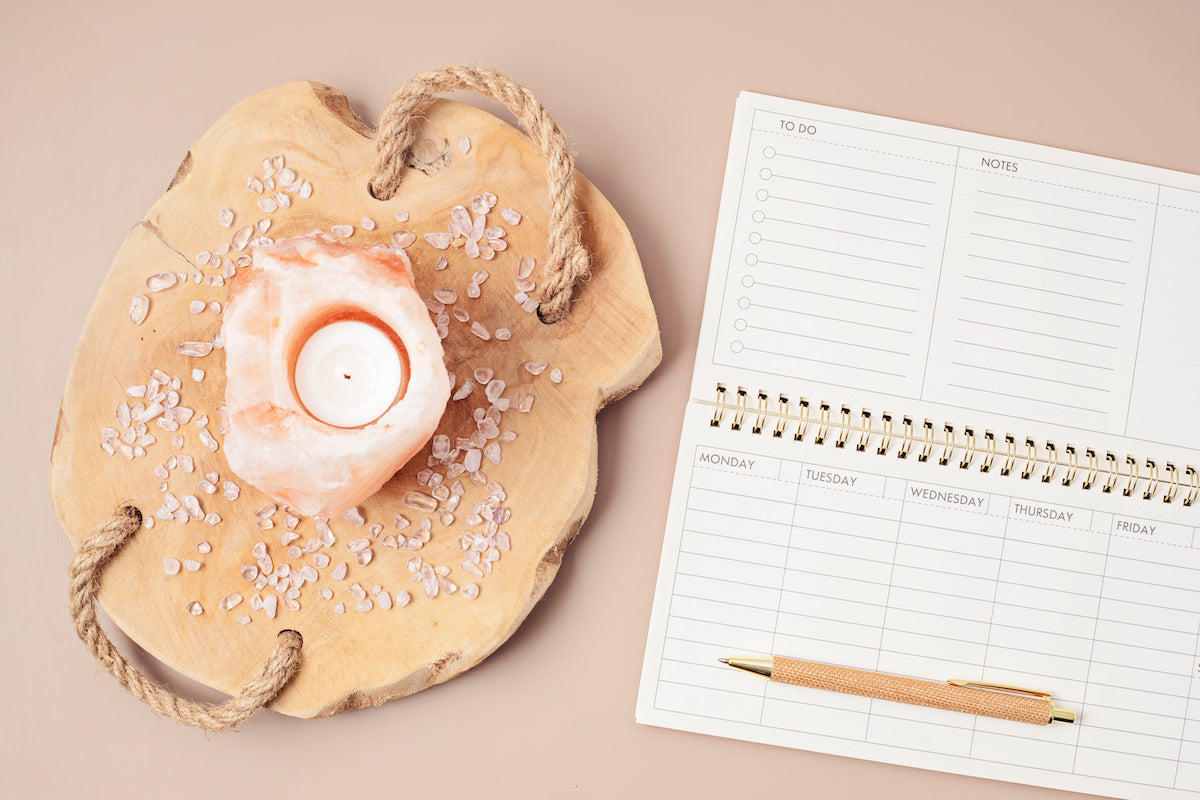 Star signs collection banner for The Tiny Topaz showing a Himalayan salt candle on a wooden tray, with a desktop calendar and pen.