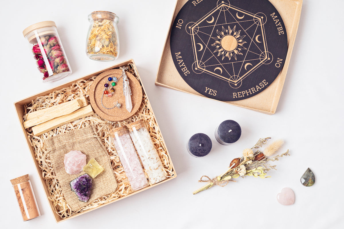 Storage collection banner for The Tiny Topaz showing an angel oracle board and a box filled with crystals on shredded paper.