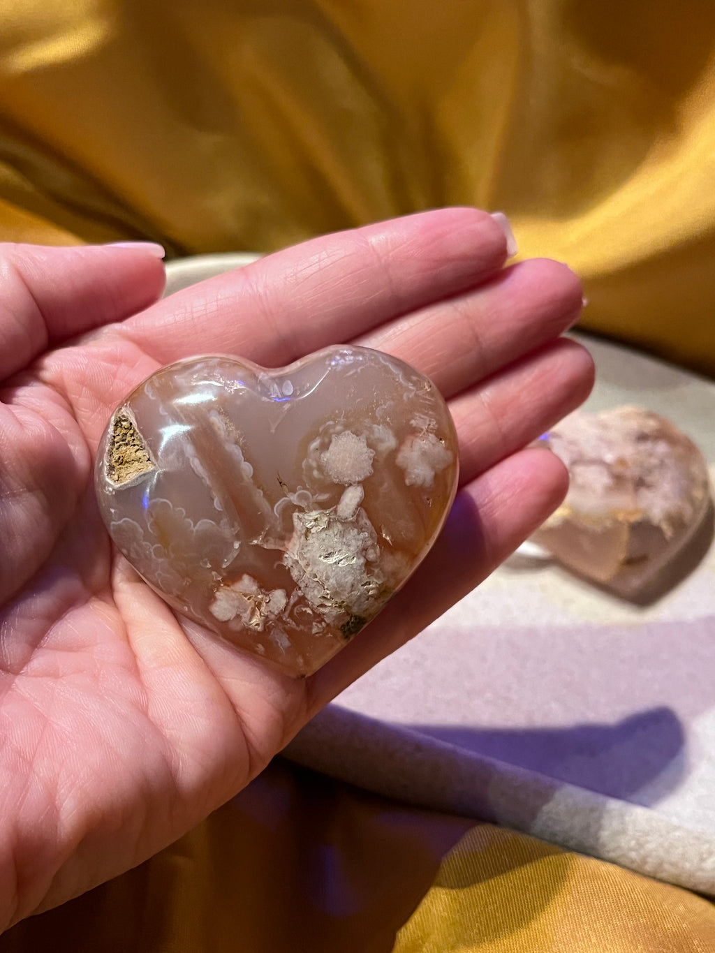 Heart shaped flower agate held in a hand