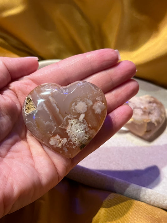 Heart shaped flower agate held in a hand